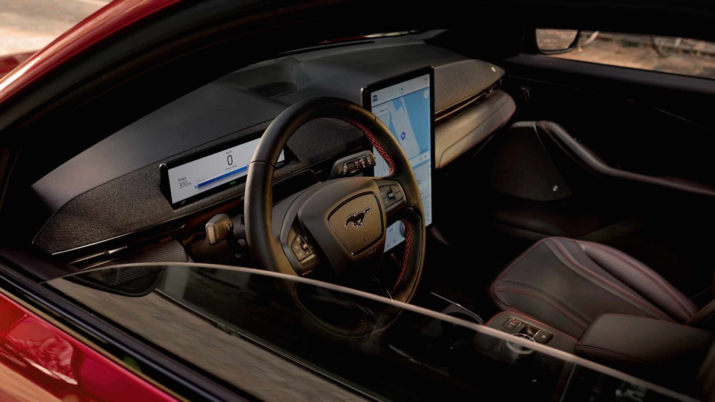 Ford Mustang Mach-E in Rot. Blick durch das offene Fenster in den Fahrzeuginnenraum