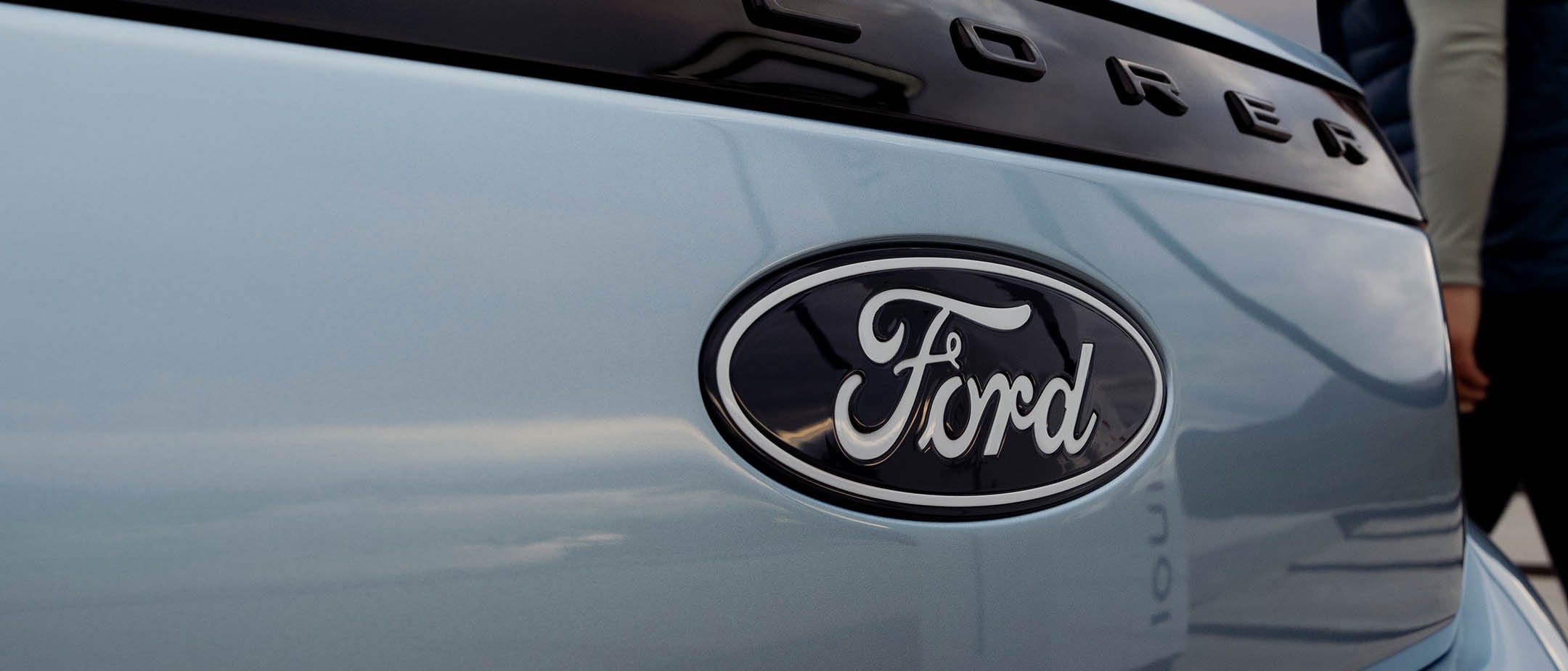 Der vollelektrische Ford Explorer in Blau. Detailansicht Ford-Logo.
